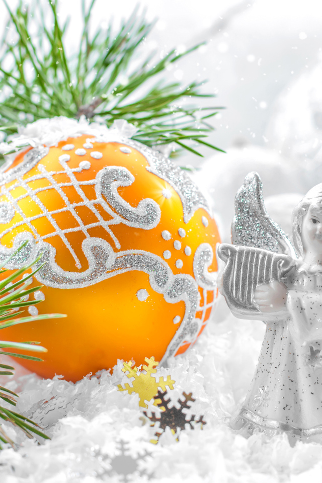 Рождественский ангел и елочная игрушка на снегу 