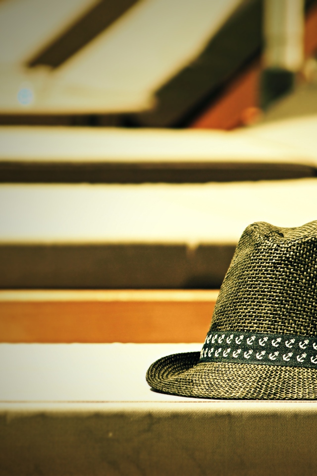 Летняя шляпа лежит на лавке в лучах солнца