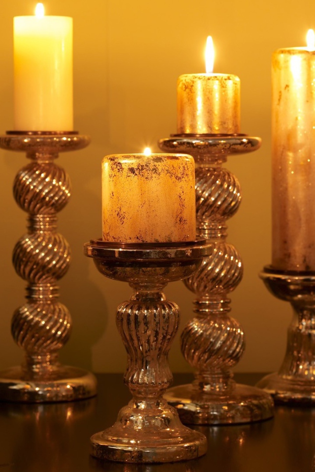 Старинные подсвечники с зажженными свечами на столе 