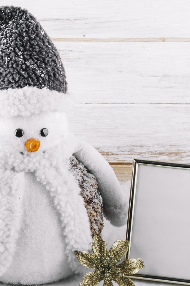 Большой игрушечный снеговик на деревянном фоне