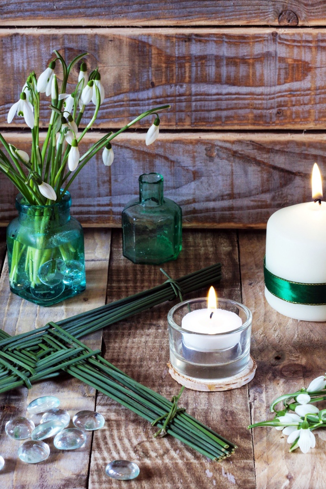 Букет подснежников на столе с зажженными свечами