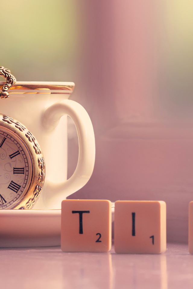 Часы с чашкой на столе с кубиками 