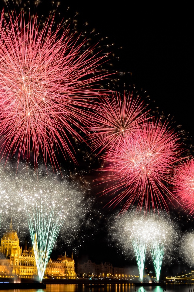 Взрывы яркого салюта над ночным городом 