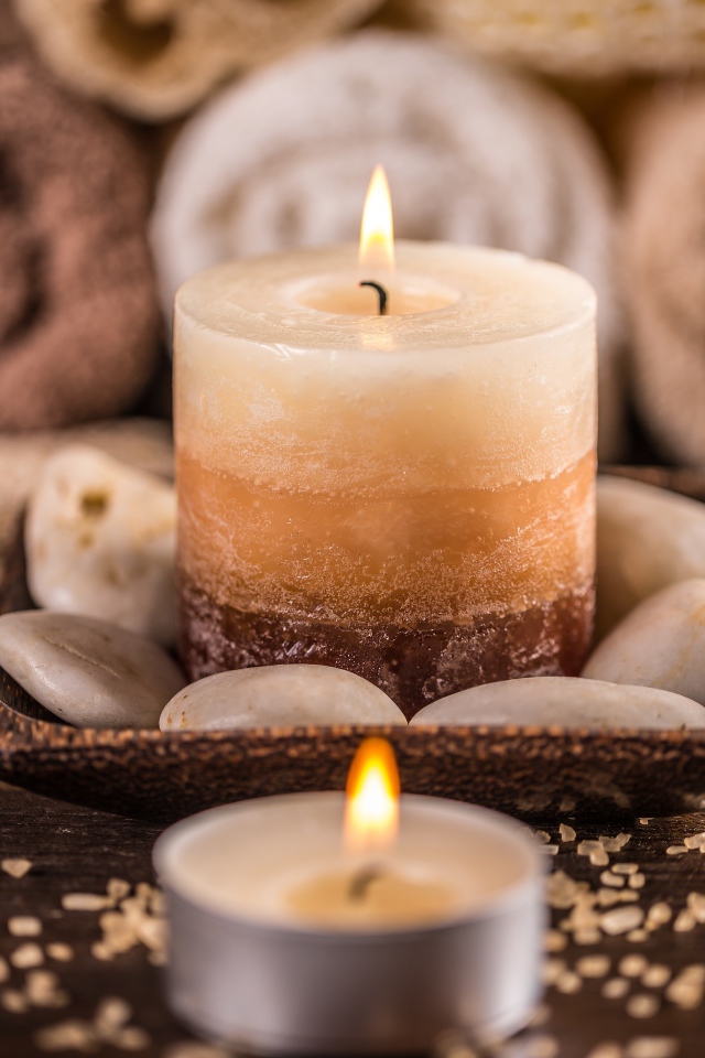 Зажженная свеча с камнями для SPA процедур