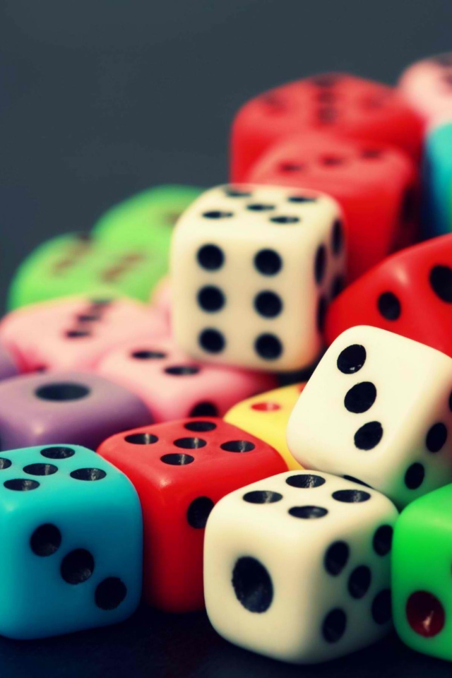 Разноцветные игральные кости на сером столе 