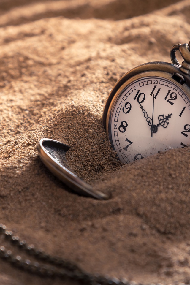 Карманные часы на цепочке в песке 