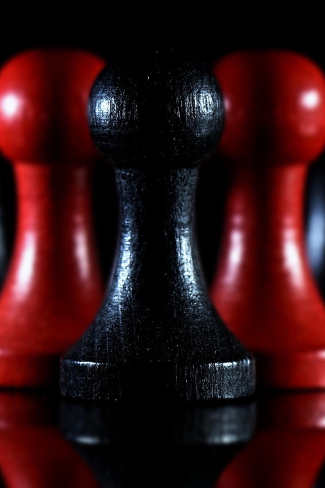 Красные и черные шахматные фигуры на черном фоне