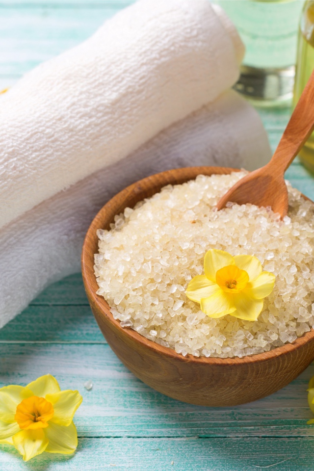 Соль с цветами нарцисса и полотенцем на столе