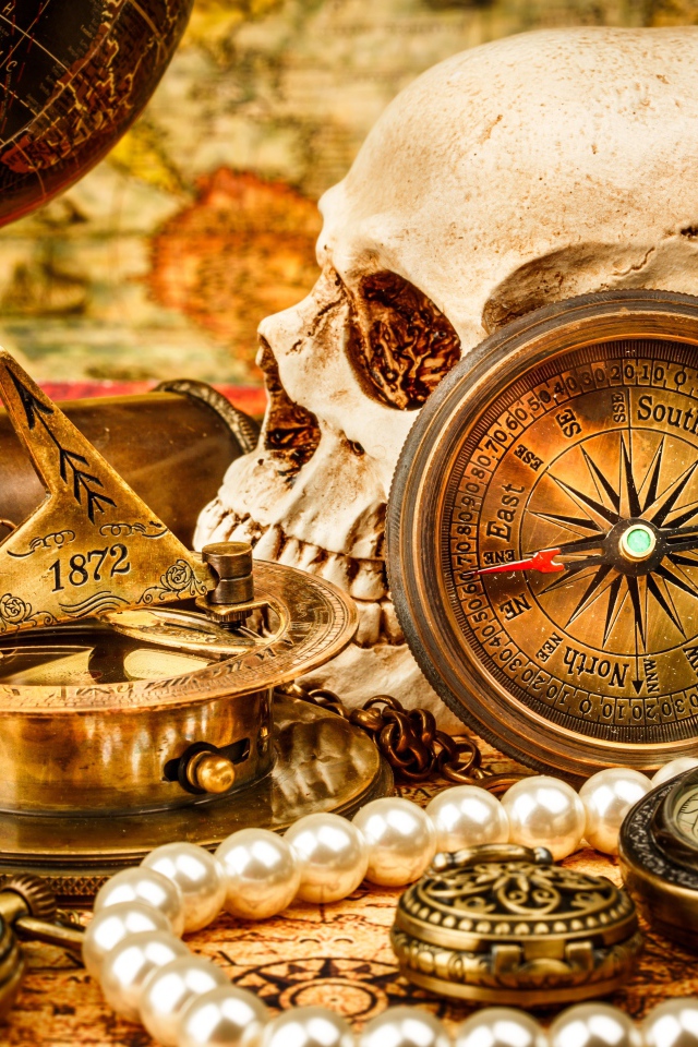 Череп, бинокль, компас, жемчуг и старинные часы на столе