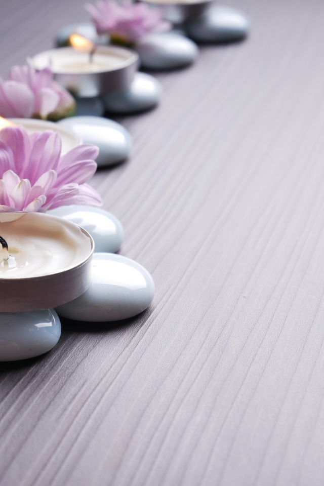 Камни с ароматическими свечами и цветами хризантемы