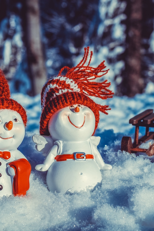 Две статуэтки снеговиков на снегу
