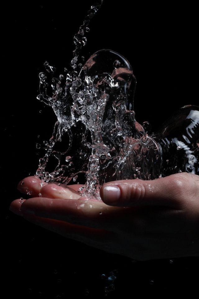 Вода в ладонях на черном фоне