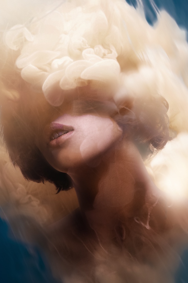 Лицо девушки в дыму на голубом фоне, иллюзия