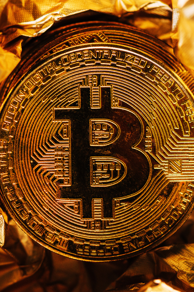 Золотая монета биткоин на фольге