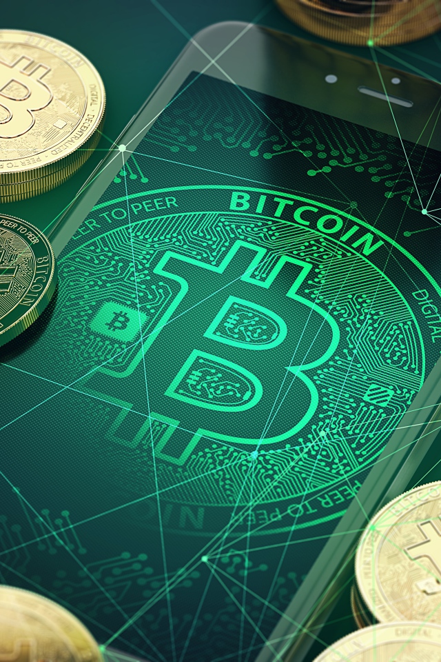 Монеты биткоин со смартфоном на столе 