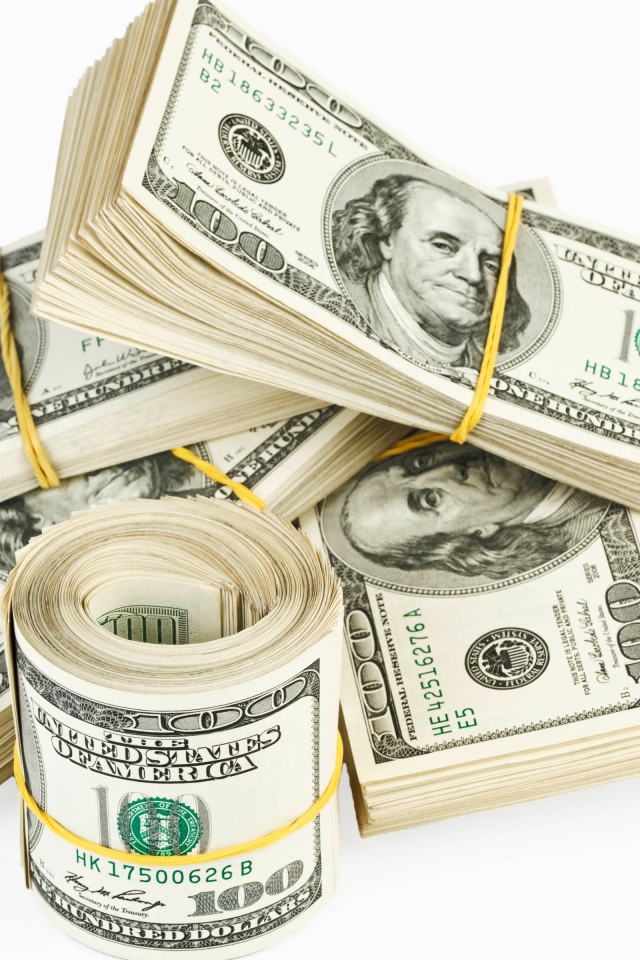 Пачки банкнот по сто долларов на белом фоне