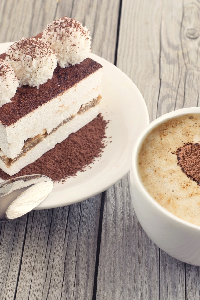 Чашка капучино с пирожным на столе 