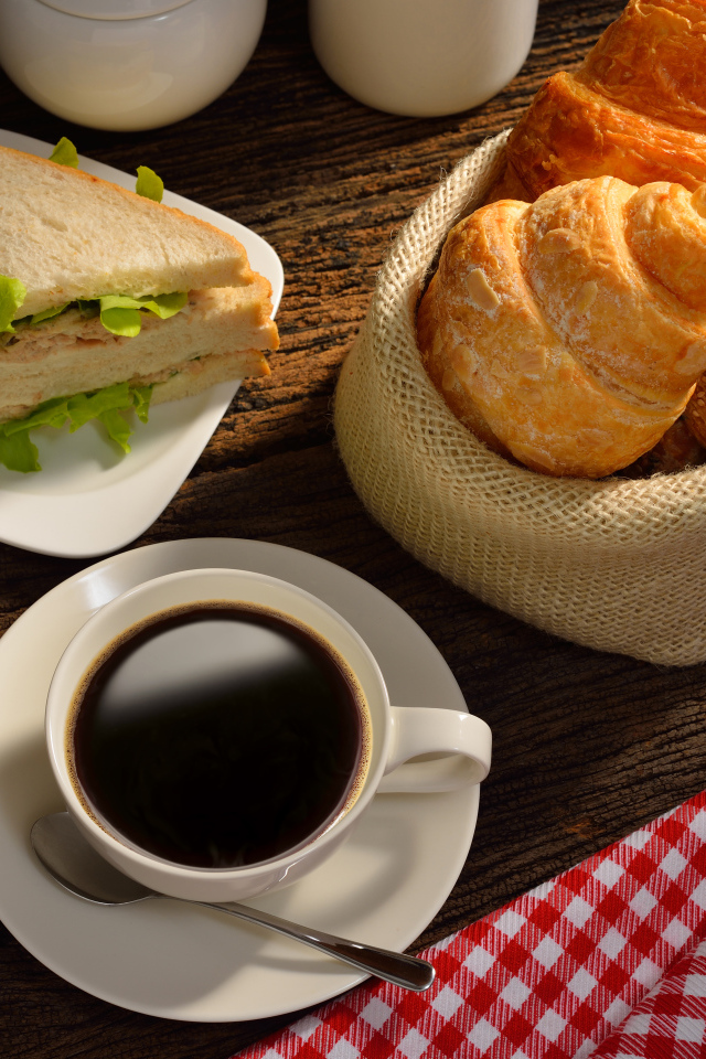 Чашка кофе с круассанами и сендвичем на завтрак