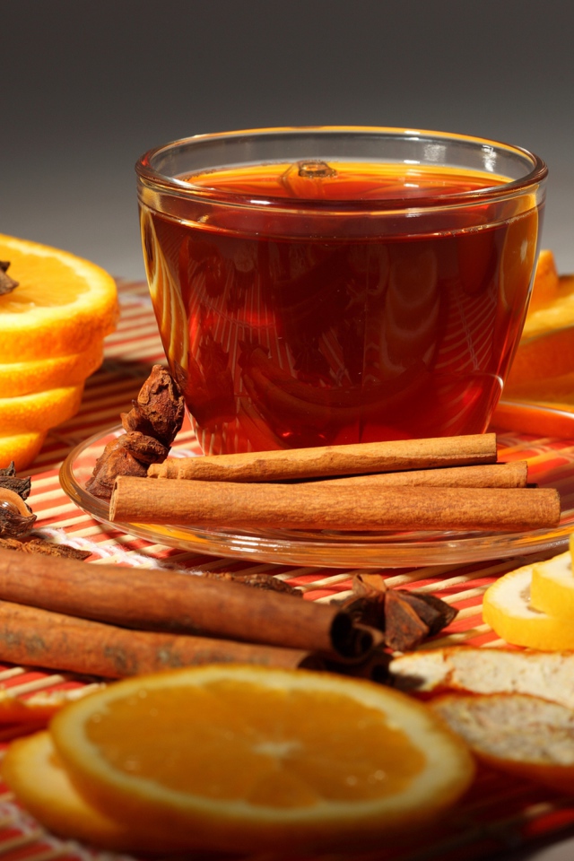 Чашка чая на столе с апельсинами, корицей и бадьяном