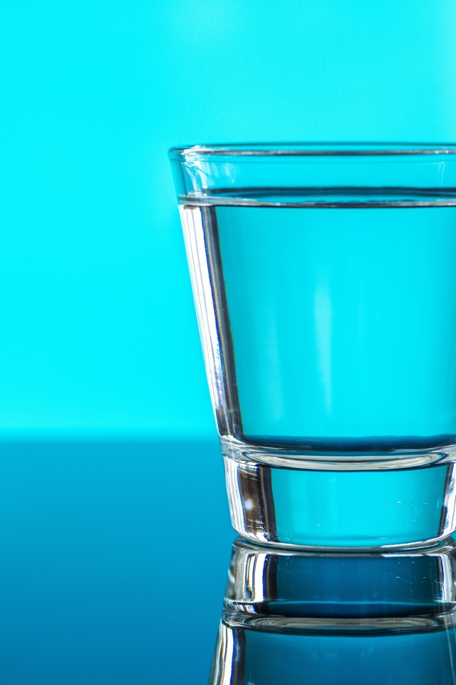 Стакан воды на голубом фоне 