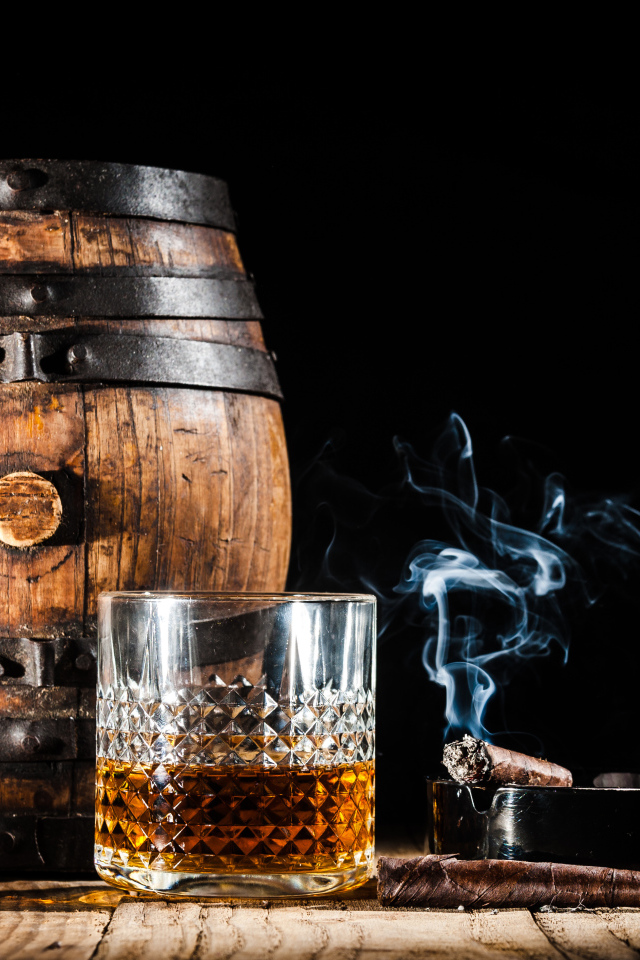 Бочонок рома, со стаканом виски и сигарой на черном фоне