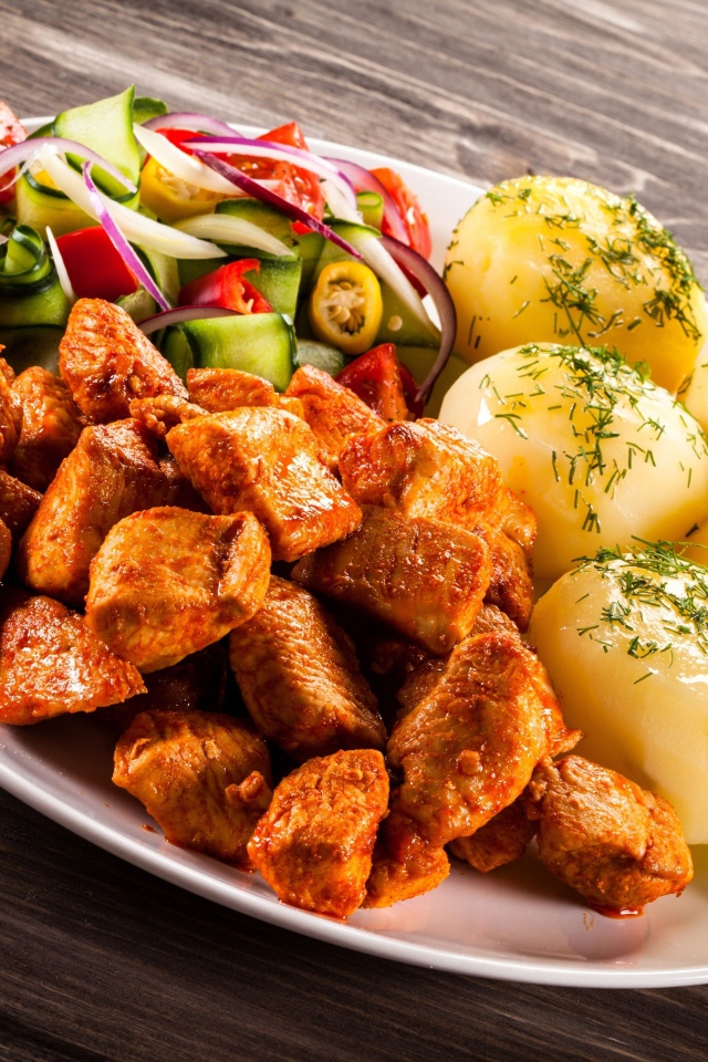 Вареный картофель с мясом и салатом на тарелке