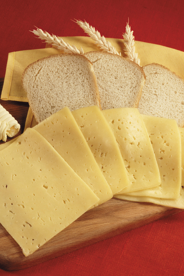 Хлеб с кусками сыра на разделочной доске