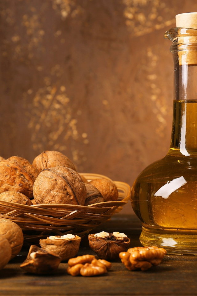 Масло в стеклянной бутылке на столе с грецкими орехами 