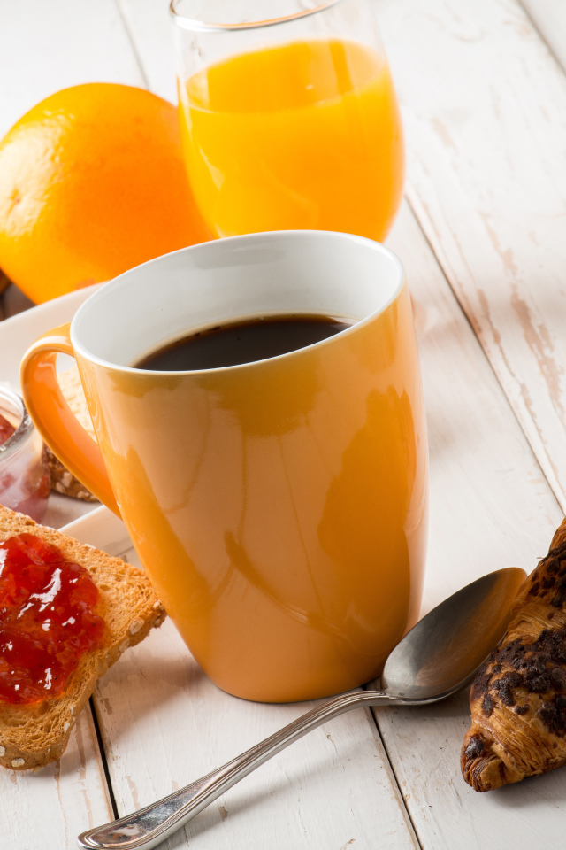 Кофе на деревянном столе с круассанами, соком и джемом 