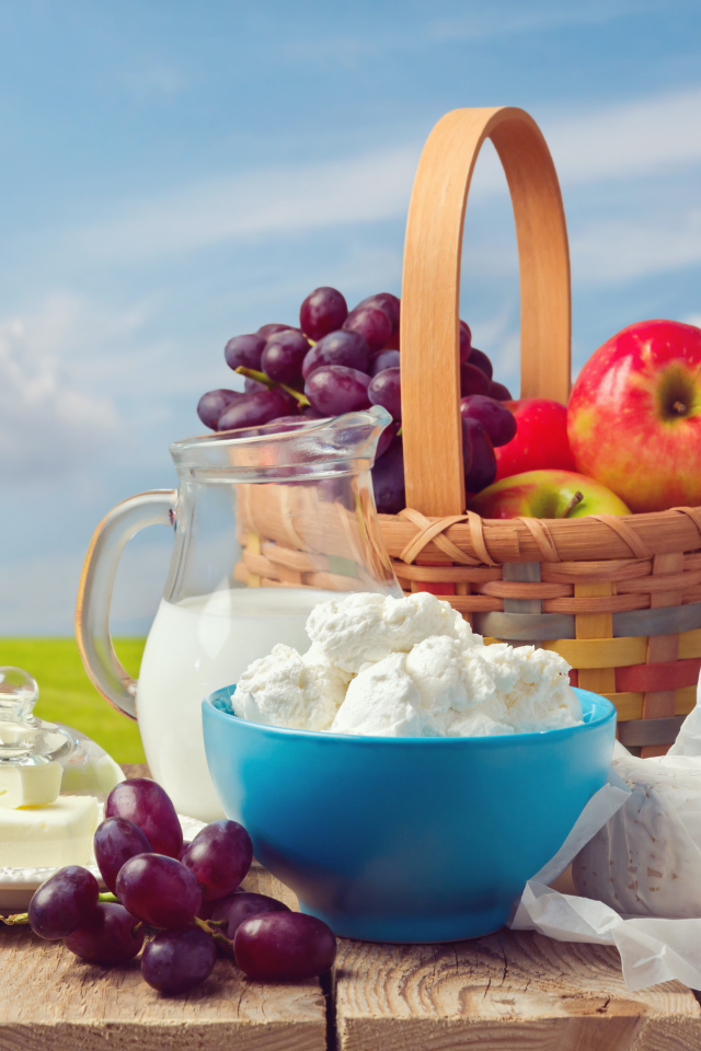 Творог с молоком на столе с виноградом и яблоками 