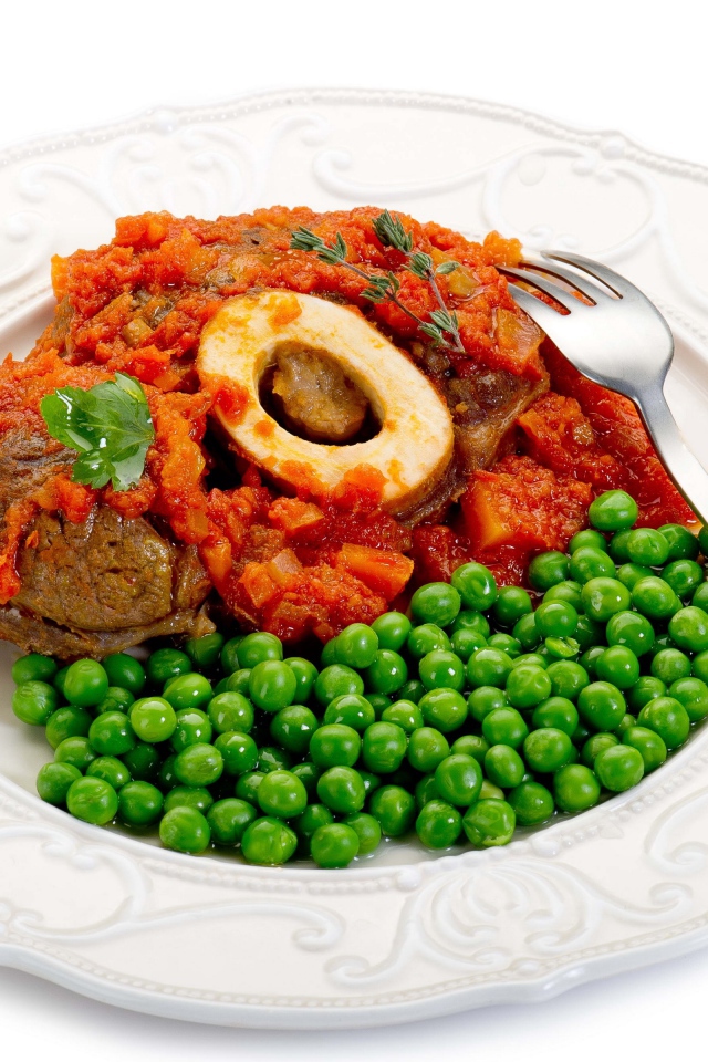 Зеленый горошек на белой тарелке с мясом