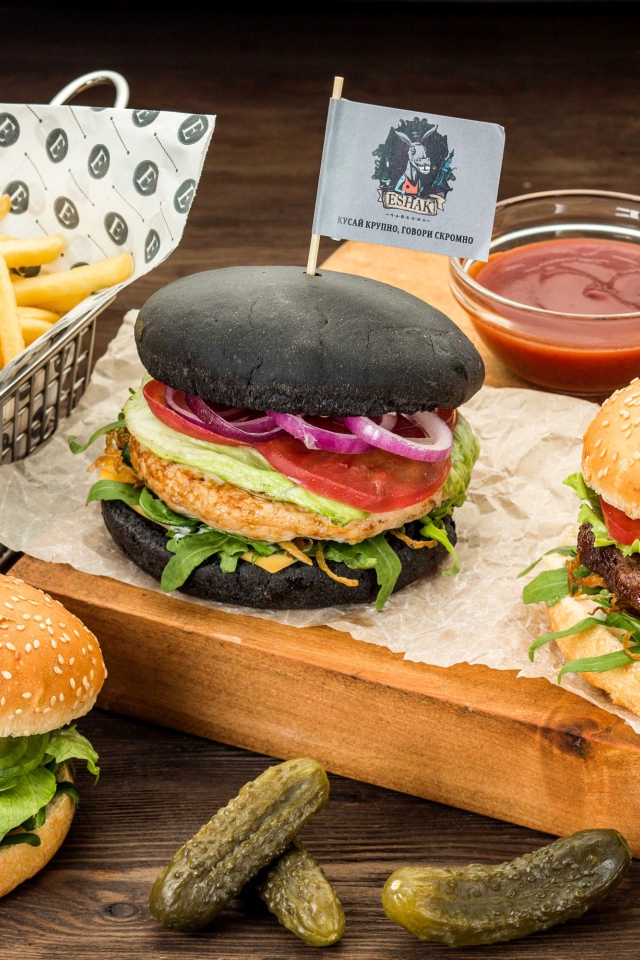 Гамбургеры с картофелем фри и солеными огурцами на столе 