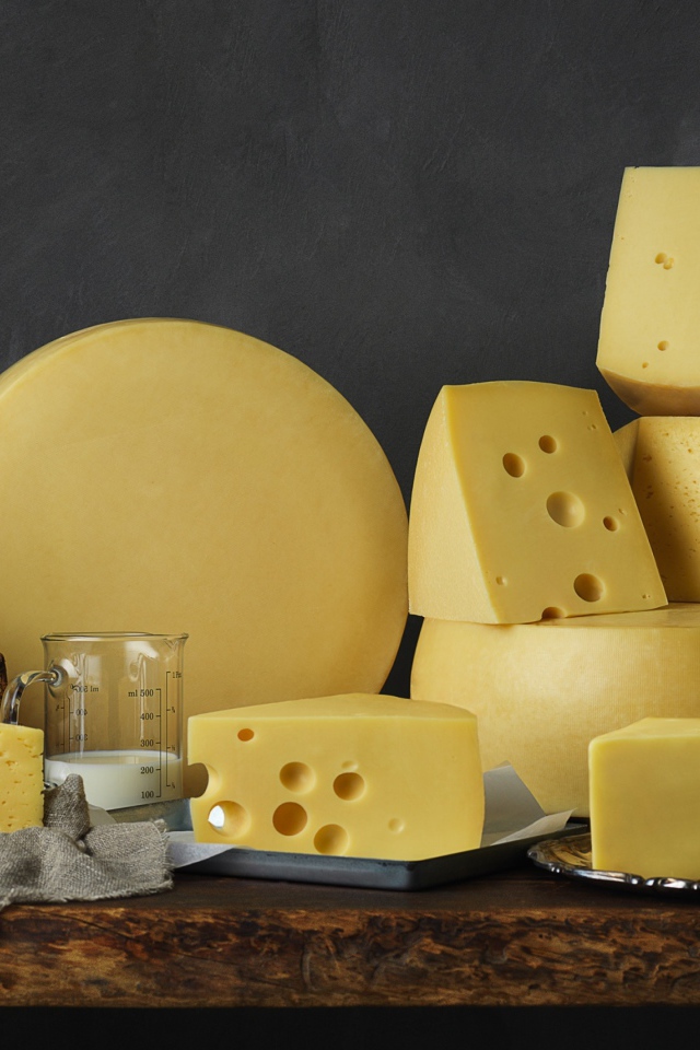 Твердый сыр на столе с книгами 