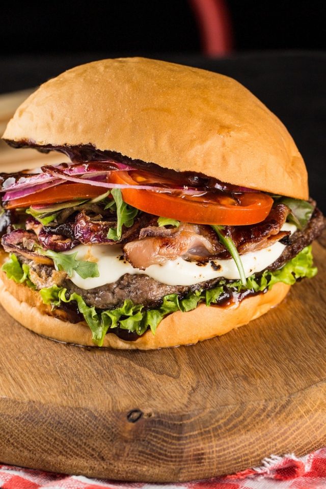 Большой аппетитный гамбургер на деревянной доске 