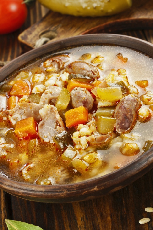 Перловый суп с сердечками на столе с помидорами 