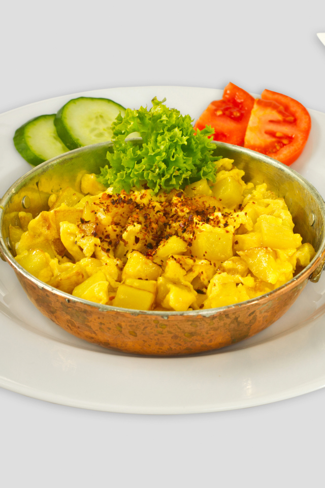 Картофель с овощами на белой тарелке