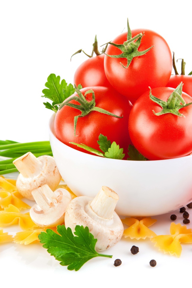 Red tomatoes, pasta, onions and champignons on a white background