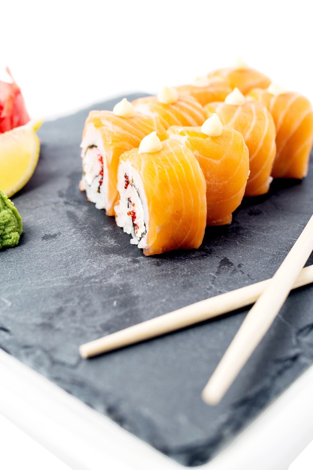 Роллы с красной рыбой на тарелке с палочками