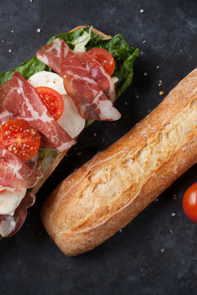 Бутерброд с ветчиной, помидорами, яйцом и листьями салата