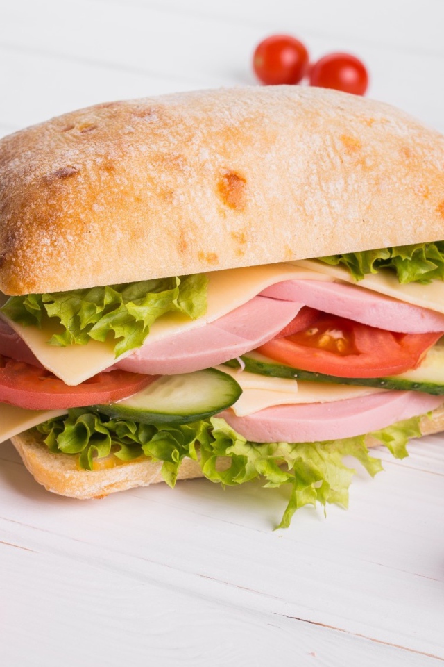 Сендвич с соусом и помидорами на столе 