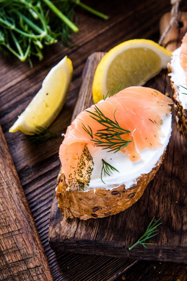 Бутерброды с сыром и красной рыбой на разделочной доске