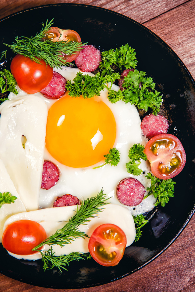 Яичница с колбасой, сыром,  помидорами и зеленью на сковороде