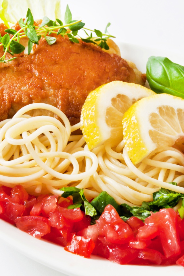 Спагетти с курицей, кусочками лимона, помидорами и зеленью