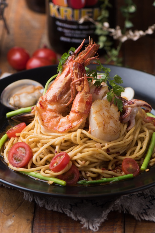 Спагетти с морепродуктами на черной тарелке