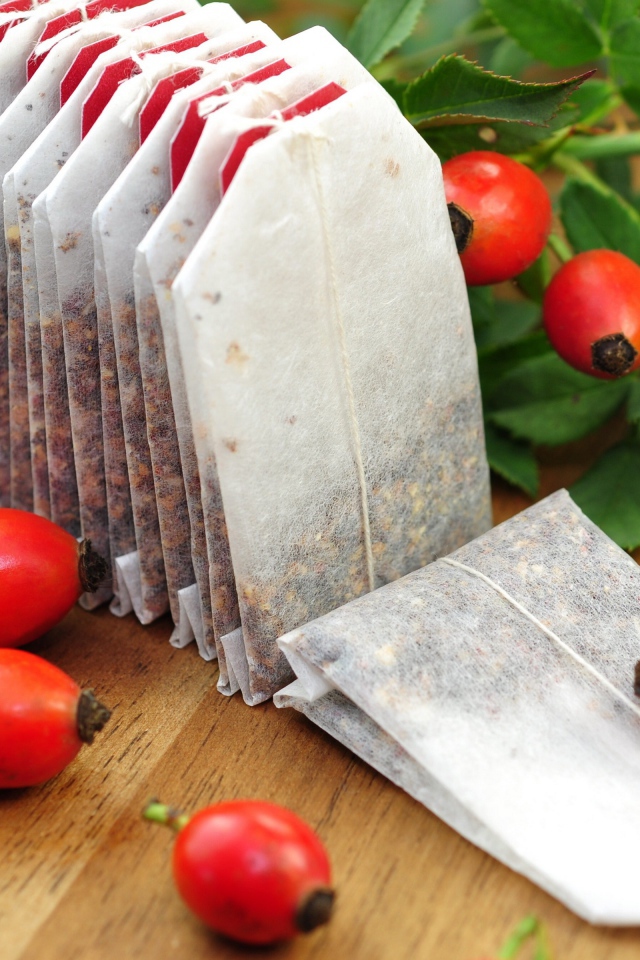 Чай в пакетиках на столе с ягодами шиповника 