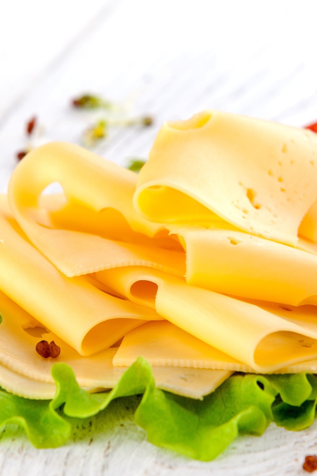 Тонко нарезанный сыр с листом салата и помидором