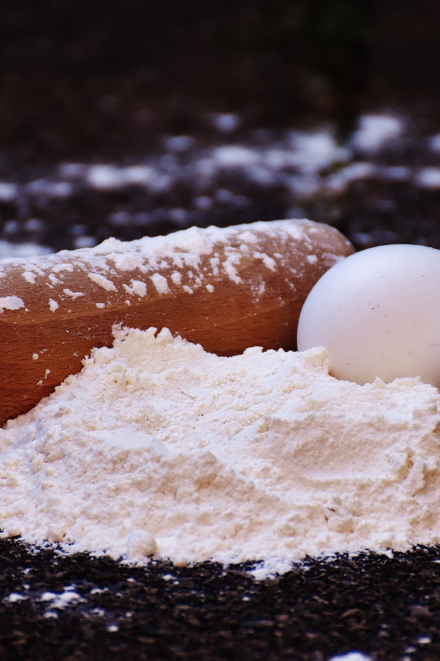 Два яйца, мука и скалка на столе