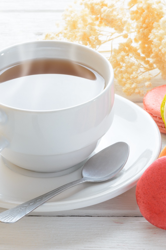 Белая чашка чая с макарунами