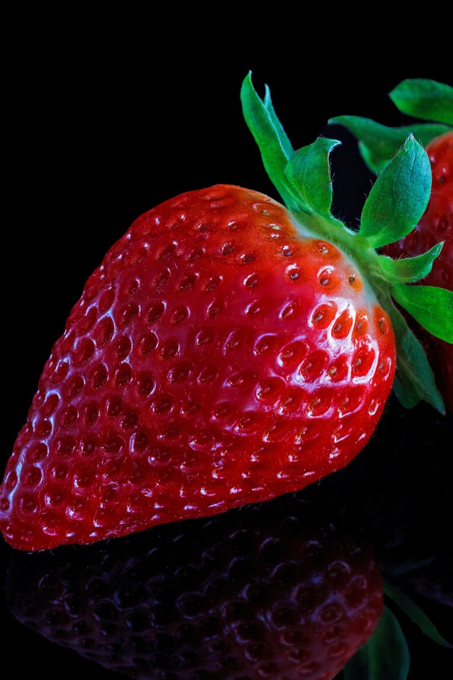 Красивая крупная красная клубника на черном  фоне