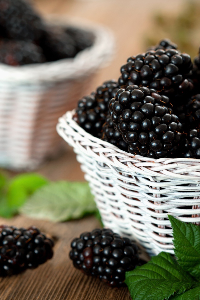 Свежые ягоды ежевики в белой корзинке на столе